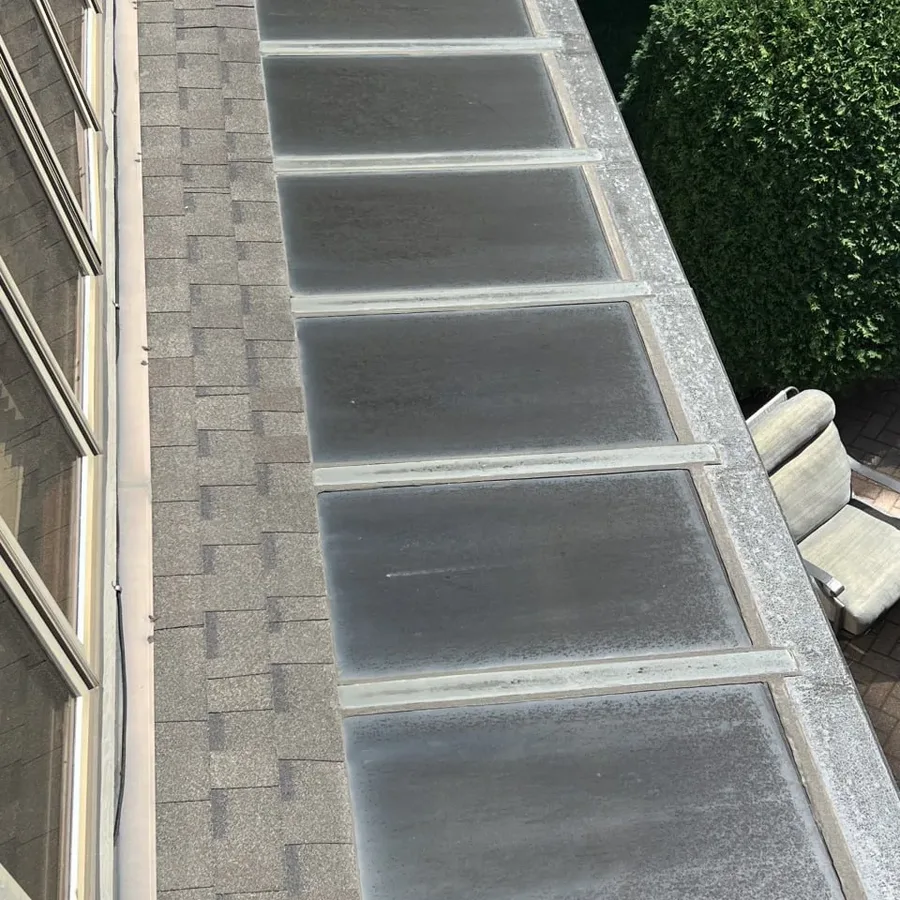 Sunroom glass panels before cleaning, clouded with dirt