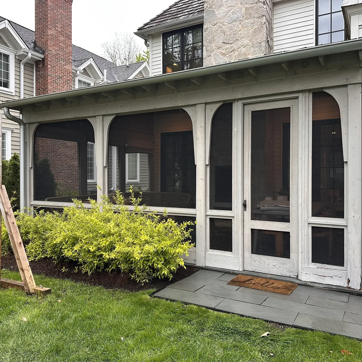Three-season room with newly installed screen panels on a residential porch