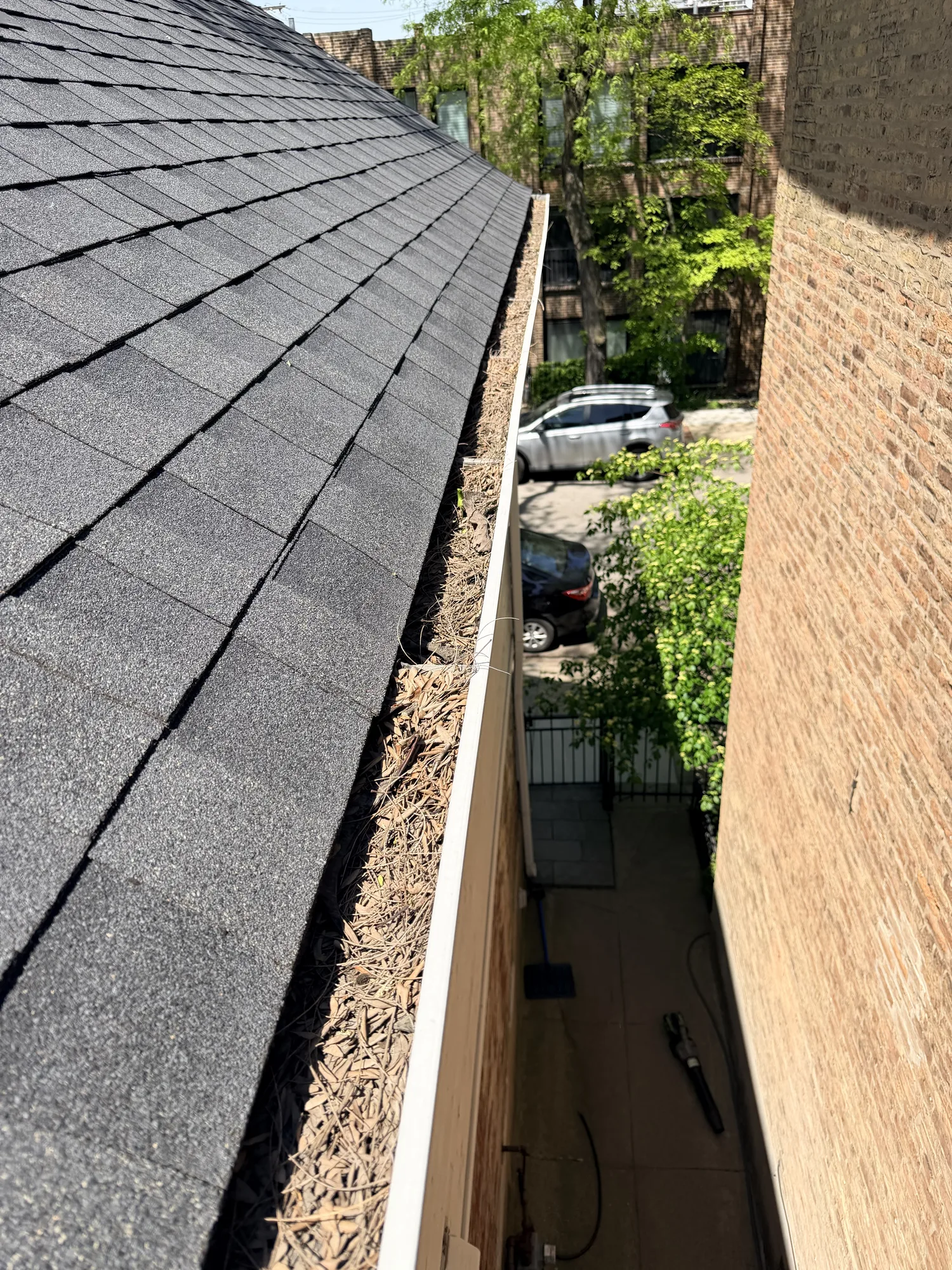 Technician-height view along the gutter line of a multi-story brick building