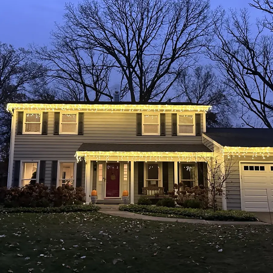 Two-story Lake Forest colonial at dusk with customer-supplied icicle lights along both rooflines
