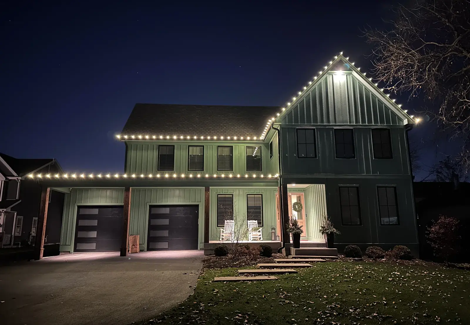 Warm white C9 lights along the roofline of a two-story home on Chicago's North Shore at night