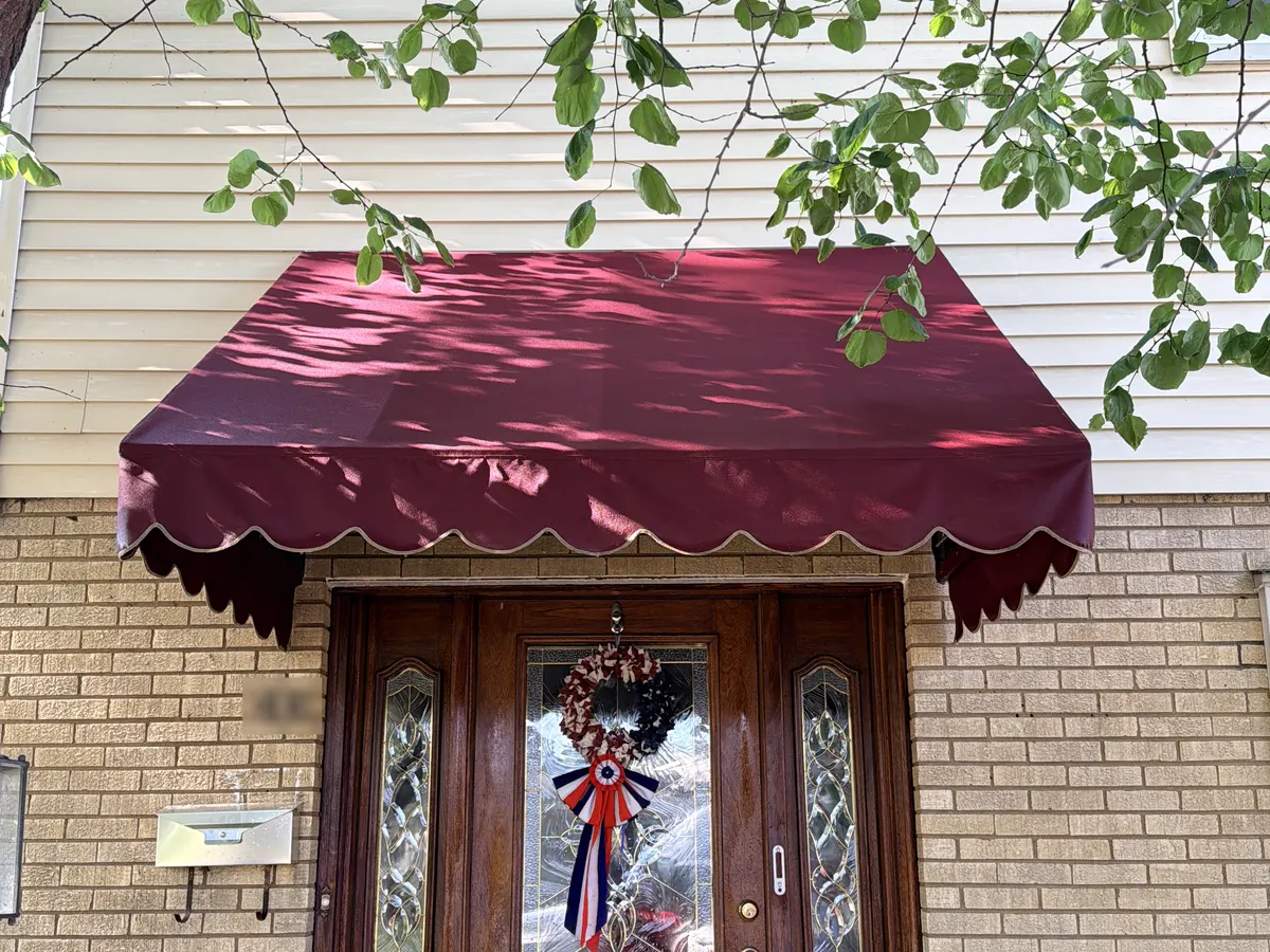 The same fabric door awning after cleaning, the panel back to an even deep red