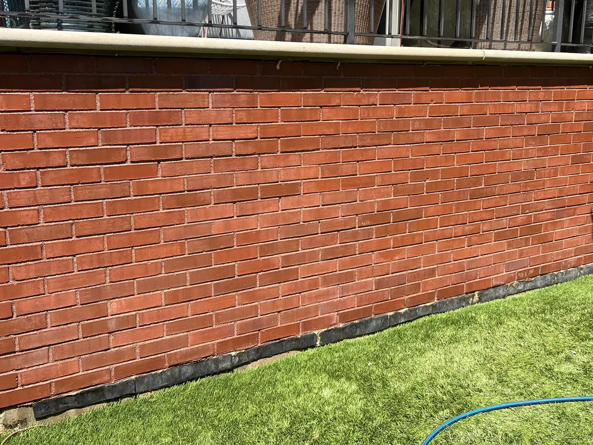 The same brick foundation wall after washing, the brick back to an even red