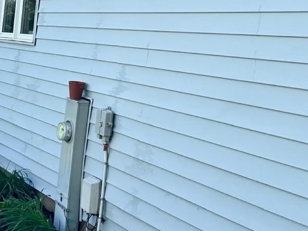 The same vinyl siding after a soft wash, the panels back to an even white